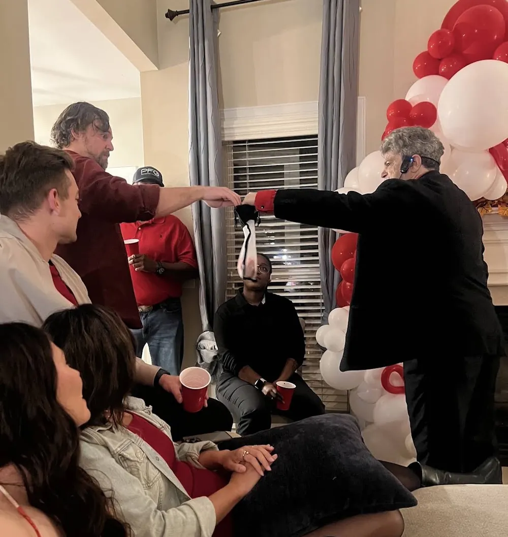 Mentalist Rick Silver performing for guests in a living room at a private birthday celebration